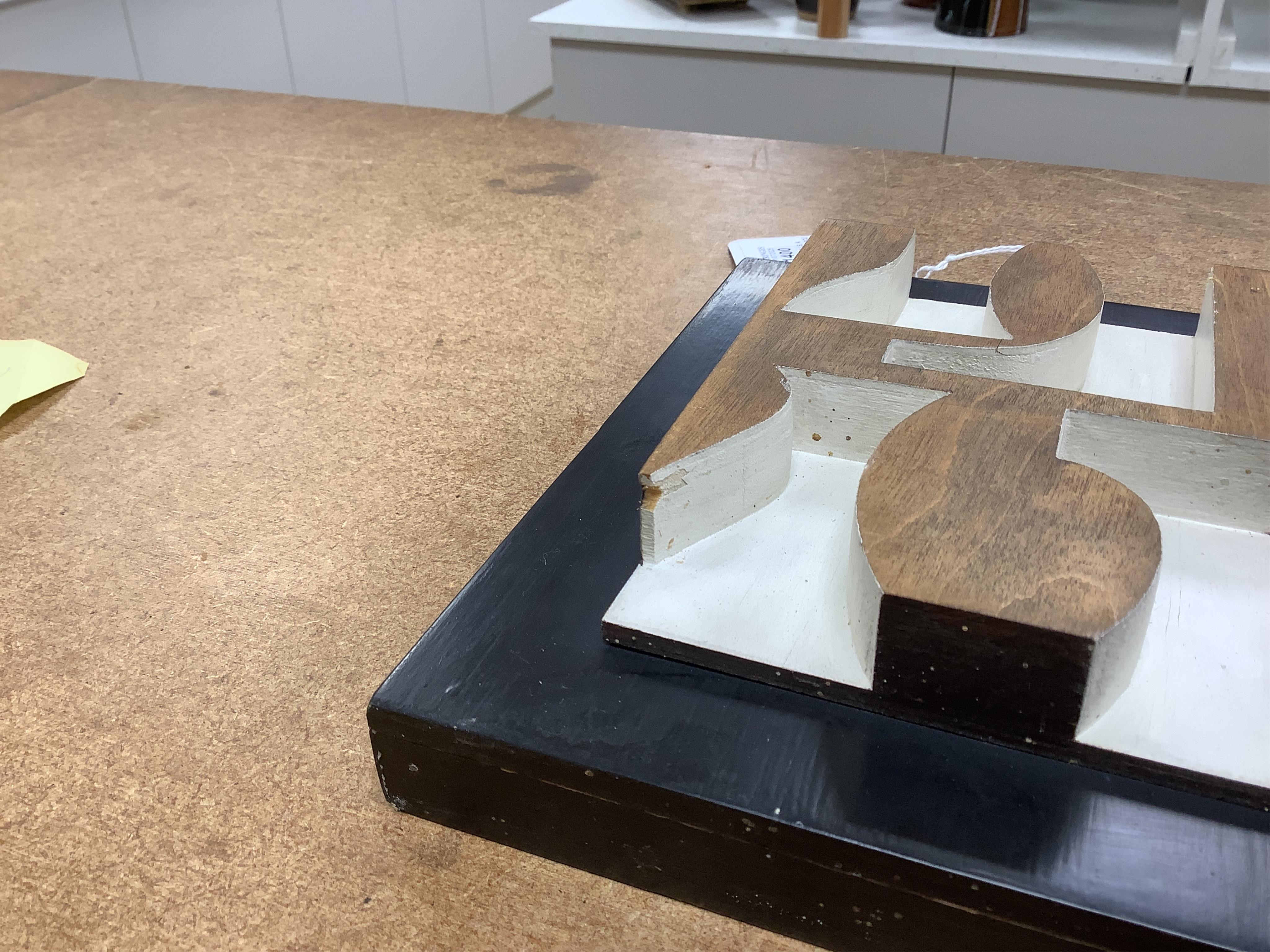 Donald Wells, a carved oak relief sculpture with gallery leaflet, 19cm high